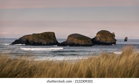 Beautiful Coastal Seastack Rocks Blanketed By A Stunning Summer Sunset Sky, Bathing In The Pacific Northwest Ocean