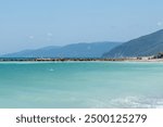 Beautiful coastal view of a bridge extending over the clear blue waters and sandy shore in a serene seaside location. Sinop, Turkey, 2024