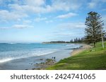 Beautiful coastal view of Torquay beach with grass lawn for tourists having picnic near the town centre. The seaside resort town is a popular travel destination. Great Ocean Road VIC Australia