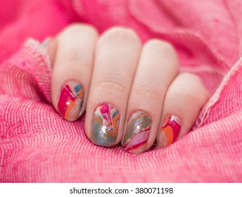 beautiful colored fingernails on a red background. water manicure
