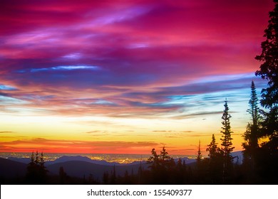 A beautiful colorful epic sunrise over the city lights of Boulder Colorado looking out from high up on the Rocky Mountains Rollins Pass and the Continental Divide west of Boulder.  