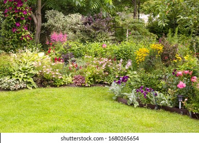 Beautiful Colorful Flower Garden With Blooming Flower Beds And A Green Lawn In Summer