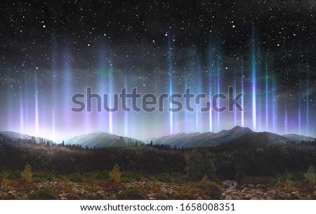 Beautiful colorful light pillars at night over the mountains