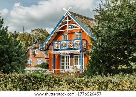 Beautiful colorful Lithuanian traditional wooden houses. Typical fisherman's house in the Baltics.Red wooden houses on the Curonian Spit.Lifestyle real estate concept.Rural architecture house facade