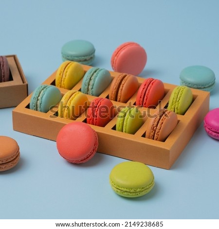 Beautiful colorful macarons. Colorful composition of different types of macaron cookies on a light blue background.