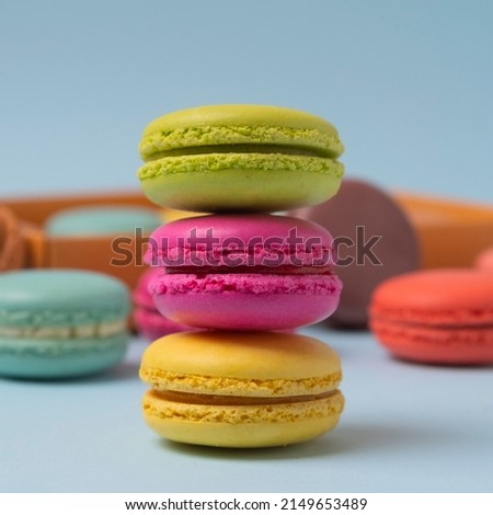 Beautiful colorful macarons. Colorful composition of different types of macaron cookies on a light blue background.