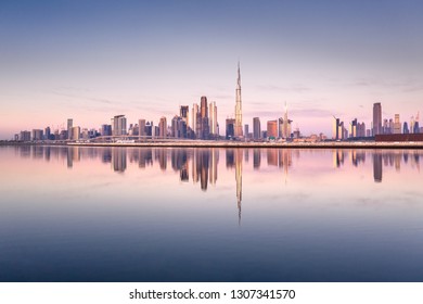 Beautiful colorful sunrise lighting up the skyline and the reflection of Dubai Downtown. Dubai, United Arab Emirates.