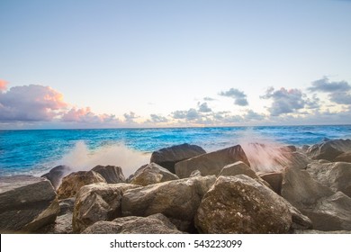 Beautiful colorful sunrise on the ocean beach with rocks and water splashes in Florida, USA