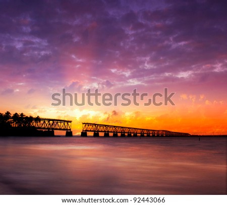 Beautiful colorful sunset or sunrise with broken bridge and sun rays spreading through purple clouds. Taken at Bahia Honda state park in the Florida Keys, near famous tourist destination of Key West.