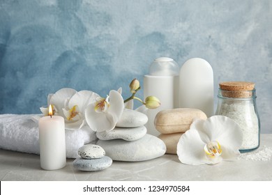 Beautiful composition with candle and spa stones on light table - Powered by Shutterstock