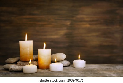 Beautiful composition with candles and spa stones on wooden background - Powered by Shutterstock