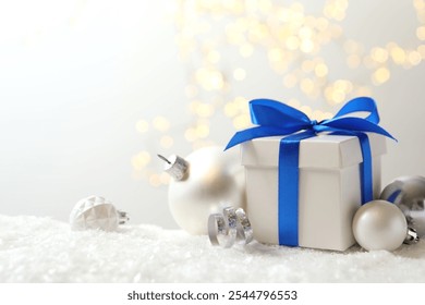 Beautiful composition with gift box on white snow 