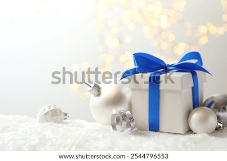 Beautiful composition with gift box on white snow 