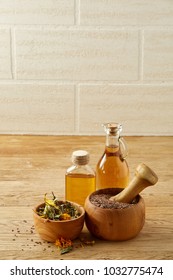 Beautiful composition of glass oil jars, wooden mortar and pestle with flax seeds, shallow depth of field