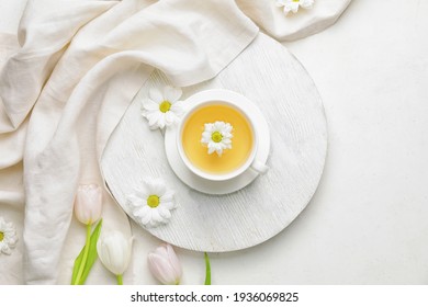 Beautiful composition with tea and spring flowers on light background