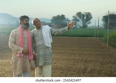 Beautiful composition of two Indian farmers standing in the field with folded hands. Agriculture concept portraying the farmers at work. The are happy to see the production and growth. - Shutterstock ID 2142421497