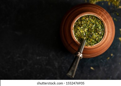 Beautiful composition of yerba mate on a black background - Juicy and green leaves without sticks