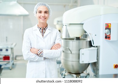 Beautiful confectionery factory worker standing in white coat with arms crossed smiling and looking at camera. - Powered by Shutterstock