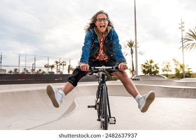 Beautiful confident senior woman with grey hair skateboarding ou - Powered by Shutterstock