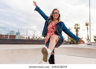 Beautiful confident senior woman with grey hair skateboarding outdoors - Pretty and youthful mature older female adult having fun at city skate park, concepts about elderly and quality of life - Powered by Shutterstock