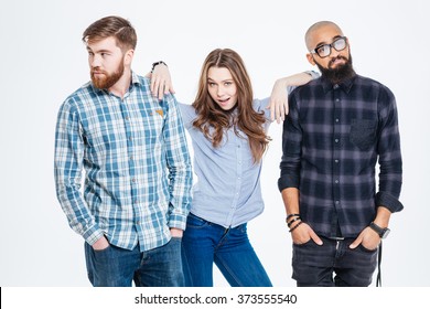 Beautiful confident young woman standing between two bearded pensive young men 