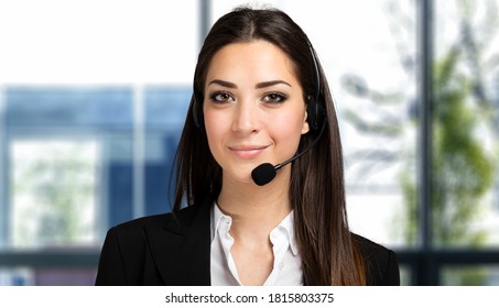 Beautiful consultant of call center in headphones in a bright office