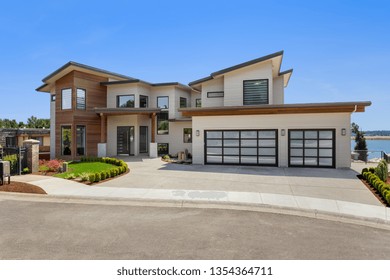 Beautiful Contemporary Home Exterior On Sunny Day. Has Three Car Garage 