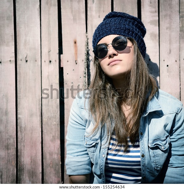 グランジ木のフェンスに帽子とサングラスをかけた美しい女の子 トーン の写真素材 今すぐ編集