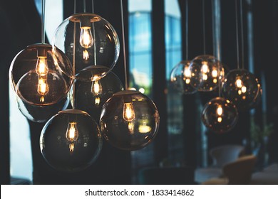 Beautiful And Cosy Luxury Light Lamp. Cosy Cafe, Coffee Shop Or Lounge Interior. Vintage And Minimal Decor. Retro Vibes. Many Different Vintage Light Bulbs Hanging From Ceiling. Soft Focus.