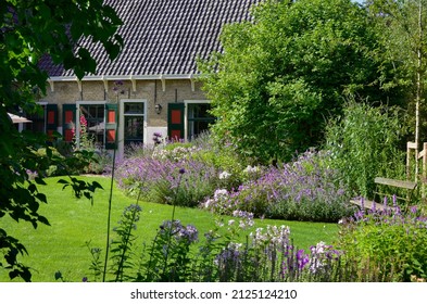 Beautiful Cottage Garden With Green Lawn And Flowering Shrubs