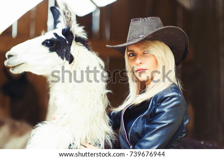Beautiful country style blonde woman with a white lama.