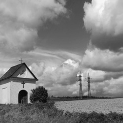 Beautiful Countryside Landscape, Small Chapel At The Field, In The Background Of High Voltage And Sky With Clouds, Outdoor, Black And White Photography