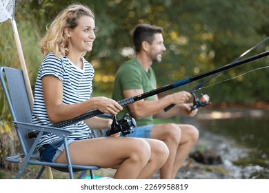 beautiful couple catching fish using a fishing rod - Powered by Shutterstock