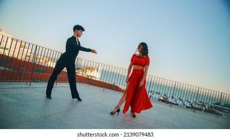 Beautiful Couple Dancing A Latin Dance Outside The City With Old Town In The Background. Sensual Dance By Two Professional Dancers On A Sunset In Ancient Culturally Rich Tourist Location.