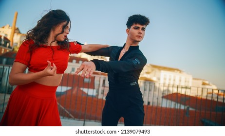 Beautiful Couple Dancing A Latin Dance Outside The City With Old Town In The Background. Sensual Dance By Two Professional Dancers On A Sunset In Ancient Culturally Rich Tourist Location.