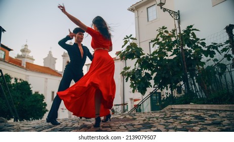 Beautiful Couple Dancing A Latin Dance On The Quiet Street Of An Old Town In A City. Sensual Dance By Two Professional Dancers On A Sunny Day Outside In Ancient Culturally Rich Tourist Location.