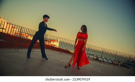 Beautiful Couple Dancing A Latin Dance Outside The City With Old Town In The Background. Sensual Dance By Two Professional Dancers On A Sunset In Ancient Culturally Rich Tourist Location.