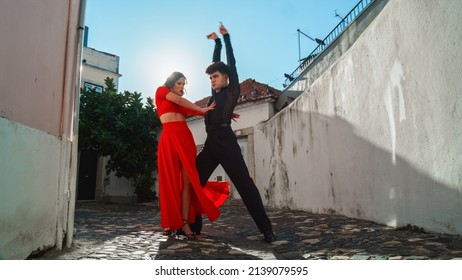 Beautiful Couple Dancing A Latin Dance On The Quiet Street Of An Old Town In A City. Sensual Dance By Two Professional Dancers On A Sunny Day Outside In Ancient Culturally Rich Tourist Location.