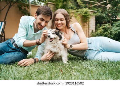 Beautiful Couple With A Dog On The Grass