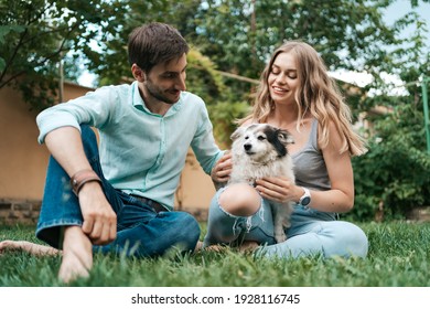 Beautiful Couple With A Dog On The Grass