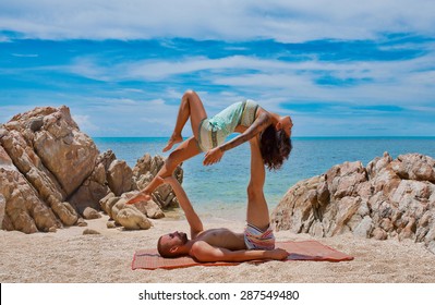 beautiful couple doing acro yoga on the beach - Powered by Shutterstock