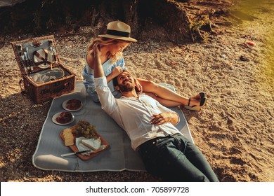 Beautiful couple enjoying picnic time on the sunset. - Powered by Shutterstock