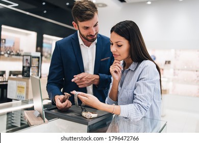 Beautiful Couple Enjoying In Shopping At Modern Jewelry Store. Close Up Shot Of Human Hand Holding Expensive Watch.