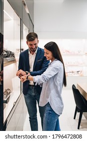 Beautiful Couple Enjoying In Shopping At Modern Jewelry Store. Close Up Shot Of Human Hand Holding Expensive Watch.