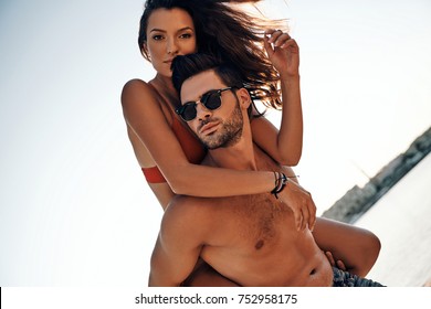 Girlfriend in black bikini riding on her man