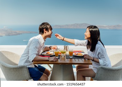 Beautiful couple having breakfast on vacation on Santorini Island, Greece. 
