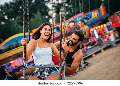 Beautiful couple having fun at luna park. Soft focus, high ISO, grainy image.