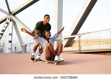 Beautiful couple having fun outdoors. Portrait of an excited young couple with skateboard. - Shutterstock ID 2023708484