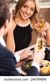 Beautiful couple having romantic dinner at restaurant. smiling woman looking at man dinking wine at toast