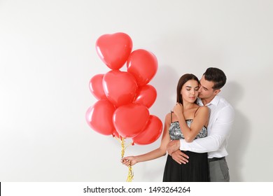 Beautiful couple with heart shaped balloons on light background, space for text - Shutterstock ID 1493264264